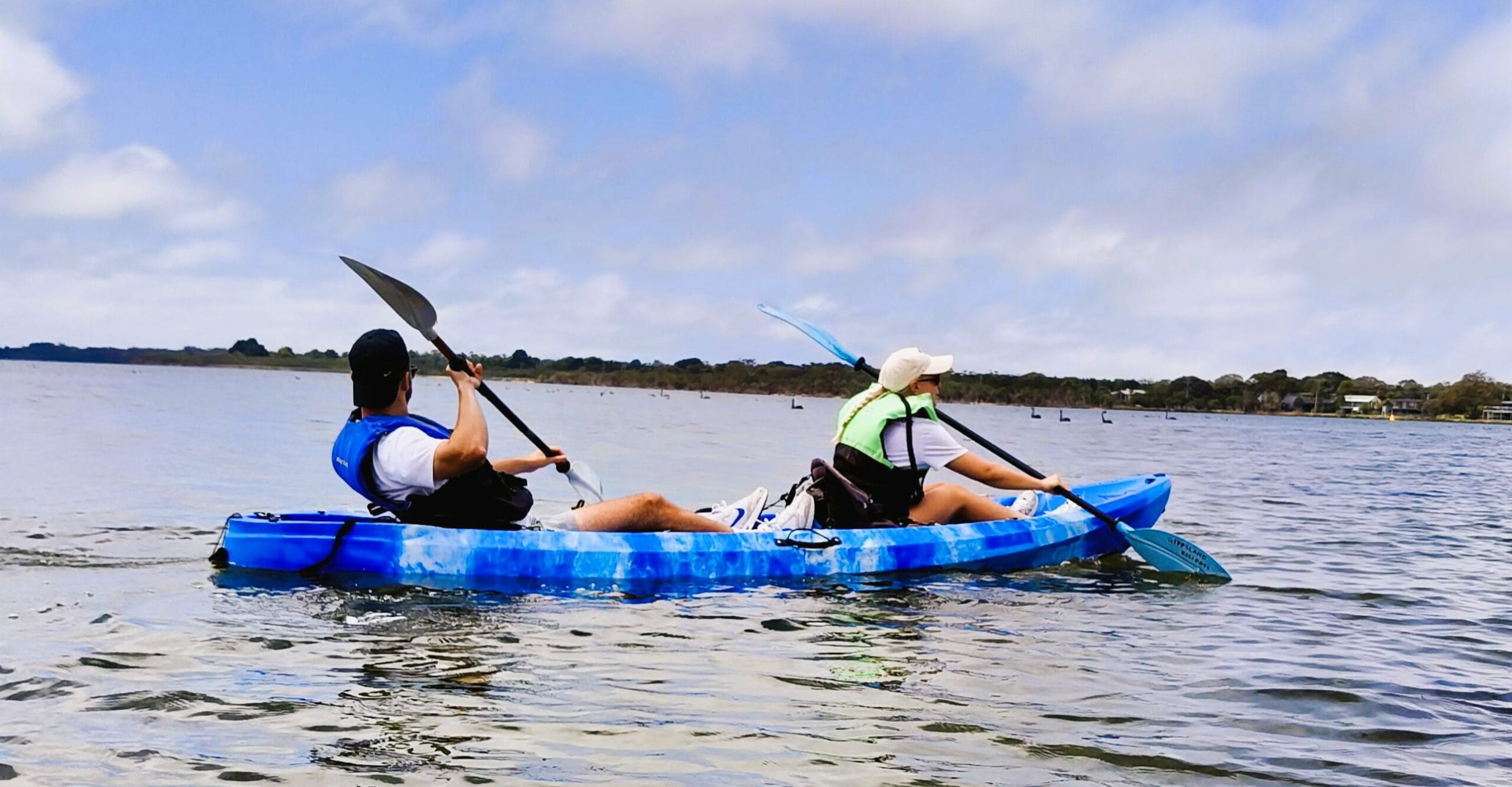 Adult couple kayaking on Gippsland Lakes in a double kayak available for hire