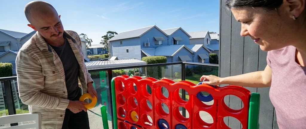 Guests playing giant Connect 4 outdoor game at Captains Cove Resort in Paynesville
